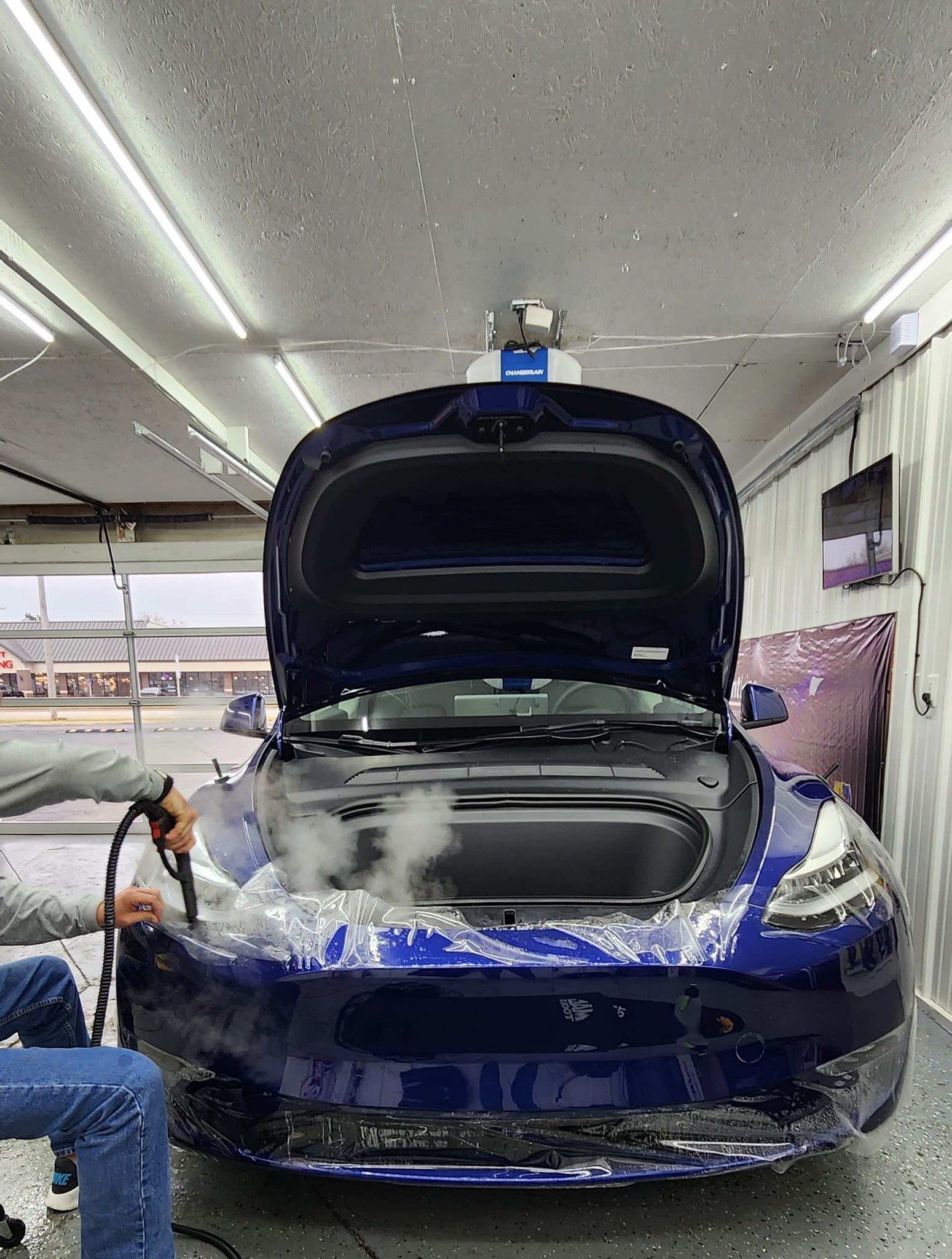 PPF being steamed onto blue Tesla Model 3 front end with hood open